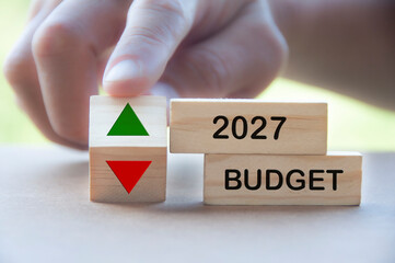 Budget 2027 text on wooden blocks with indication budget up and down. Budgeting concept.