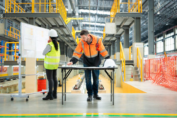 Male and female engineers work together in an electric repair station, Check the details of the...