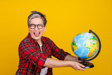Profile portrait of overjoyed grandmother have good mood arms hold world globe isolated on yellow...