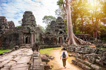 Female tourist walking to ancient Angkor temple in Cambodia