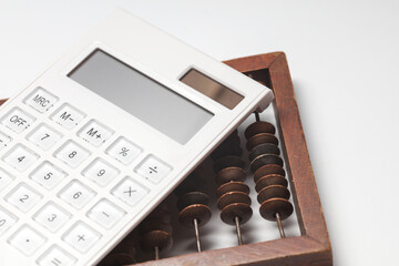 Retro wooden abacus with calculator on white background. Business concept