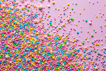 Colorful Sprinkles on Pink Background, CloseUp Macro Photography of Multicolored Sugar Sprinkles on Vibrant Background