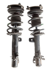 Shock absorber struts with black springs after being used on a car during replacement and repair on a white isolated background. Used spare parts. Auto parts catalog.