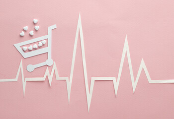 Healthy heart concept. Paper-cut heart rhythm cardiogram with shopping trolley and heart-shaped...