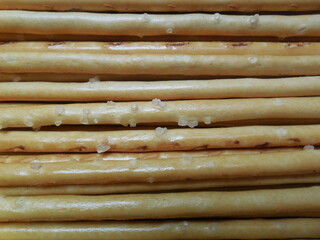 Thin crispy bread sticks, straws, appetizer, made with coarse salt.