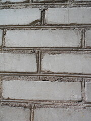 The old wall of long white-gray brick was restored and reinforced with a metal rod.