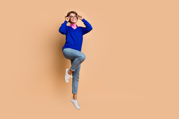 Fototapeta na wymiar Full body photo of active cheerful lady jumping hands touch eyeglasses empty space isolated on beige color background