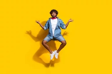 Tuinposter Full length photo of handsome young guy jump yoga meditate om wear trendy denim garment red scarf isolated on yellow color background © deagreez