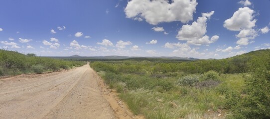 View over an gravel road in the Namibian Kalahari during the day under a blue sky