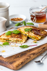 Homemade naan breakfast sandwiches served with honey, basil and chilis.