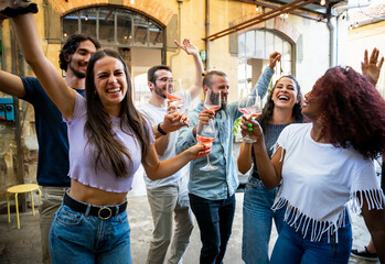 Group of friends have fun at a party dancing and joking while drinking wine and celebrating on a summer day - 770813849