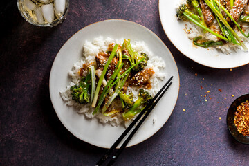 Plates of homemade Mongolian Beef served with broccoli, green onions and rice.