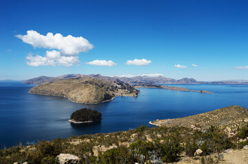 Beautiful landscape composed of islands and mountains on Lake Titicaca in Bolivia with blue sky with clouds
