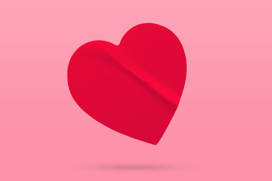Red color heart shape sticker isolated on pink background