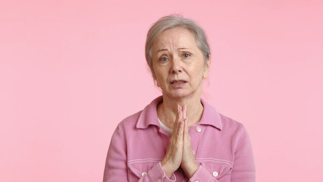 With folded hands and a hopeful demeanor, this senior woman stands in prayer, seeking guidance and assistance, her face a picture of serene faith. Camera 8K RAW. 