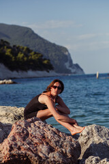 A young beautiful girl posing against the background of the sea