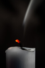 Glühender Kerzendocht mit Rauch von vergangenem Feuer vor dunklem Hintergrund - obrazy, fototapety, plakaty