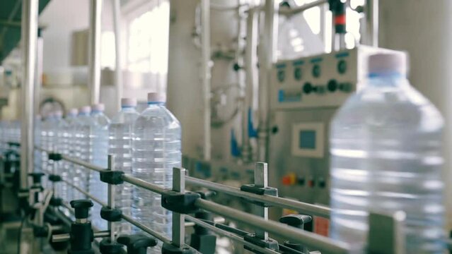 Industry Machine Process. full plastic water bottles filling with liquid. production quality check