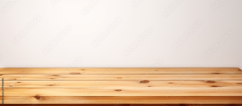 Poster a rectangular wooden table with a smooth varnished surface stands against a white wall, creating a s