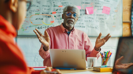 A professional gestures while explaining a concept with a whiteboard in the background.
