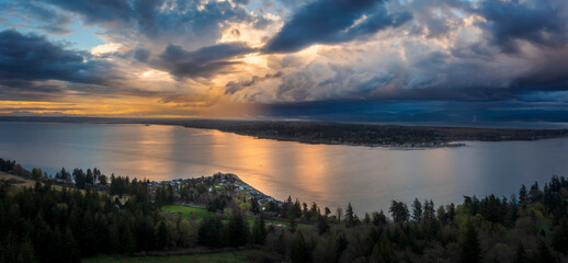 Sunset and Dramatic Clouds Over Hale Passage From Lummi Island, Washington. Aerial drone view of Lane Spit and Gooseberry Point across Hale Pass in the Salish Sea area of western Washington state.