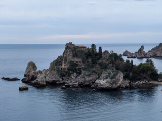 Fototapeta na wymiar Panoramic view of beautiful Isola Bella, small island near Taormina, Sicily, Italy. Narrow path connects island to mainland Taormina beach surrounded by azure waters of Ionian Sea.