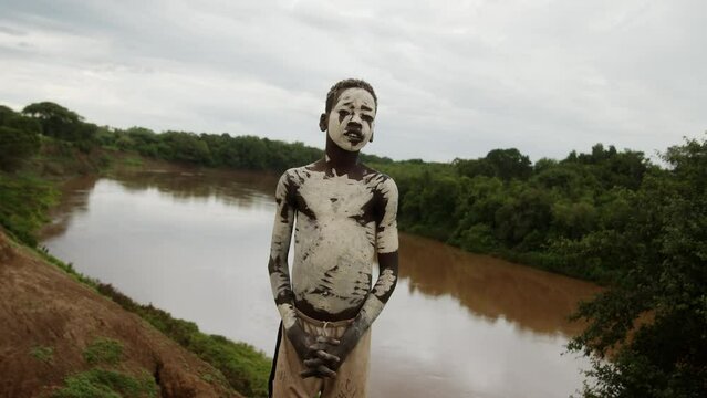Kid with Face and Body Paint next to a River