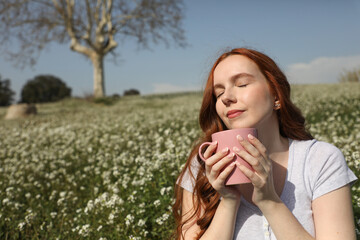 Young woman enjoys a cup of coffee surrounded by nature