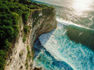 Aerial view of coastline with cliffs, ocean with waves at sunset - 770876806