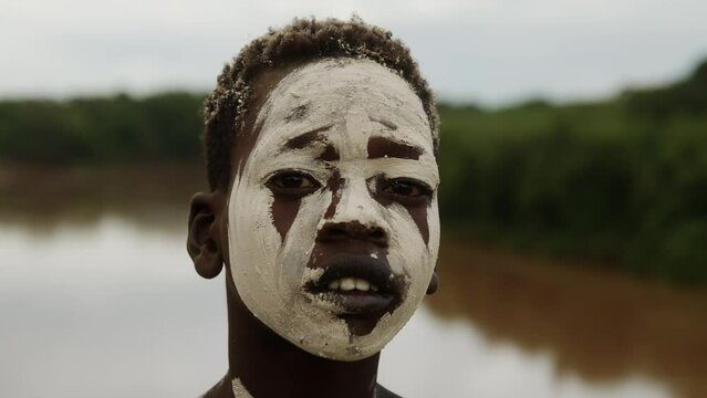 Closeup of a Kid with Face and Body Paint next to a River