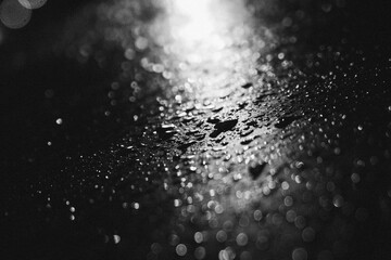 drops of water in black and white cinematic moody, iluminated by a streetlight