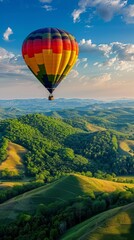 Colorful hot air balloon floating above rolling green hills under a bright sky.