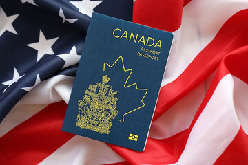 Canadian passport on United States national flag background close up. Tourism and diplomacy concept - obrazy, fototapety, plakaty