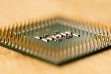 Close-up of a processor's pins on a wooden table. Selective focus.