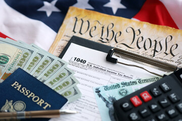 United States 1040 tax form individual income tax return with refund check and US dollar bills close up
