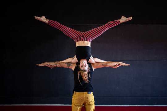 Skilled circus artist standing on partner shoulders