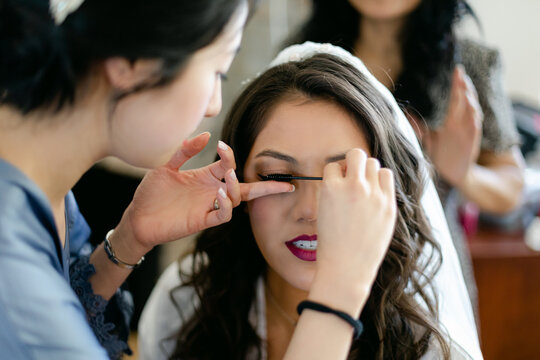 Makeup Artist Putting Mascara on Bride's Eyelashes