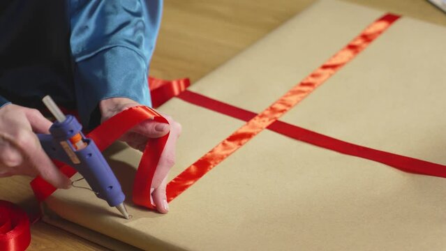 Trying on red ribbon and gluing it to craft