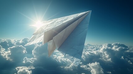   A paper plane soars in the sky, above clouds, as sunlight graces its wingtop