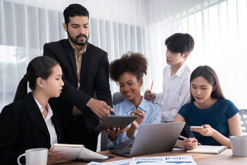 Happy diverse business people work together, discussing in corporate office. Professional and diversity teamwork discuss business plan on desk with laptop. Modern multicultural office worker. Concord