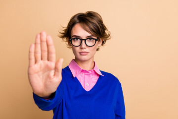 Photo of serious confident lady arm palm demonstrate stop symbol empty space isolated on beige...
