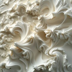   A tight shot of a pristine white frosted cake, adorned with swirling icing atop