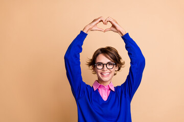 Photo of lovely cheerful lady toothy smile arms fingers demonstrate heart symbol empty space...