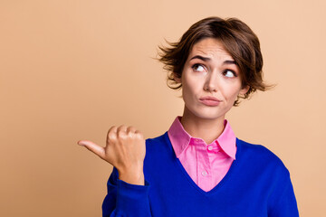 Photo portrait of pretty young girl point skeptical empty space wear trendy blue outfit isolated on...
