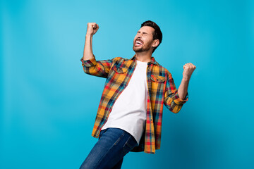 Photo portrait of nice young guy raise fists scream yeah excited dressed stylish checkered garment...
