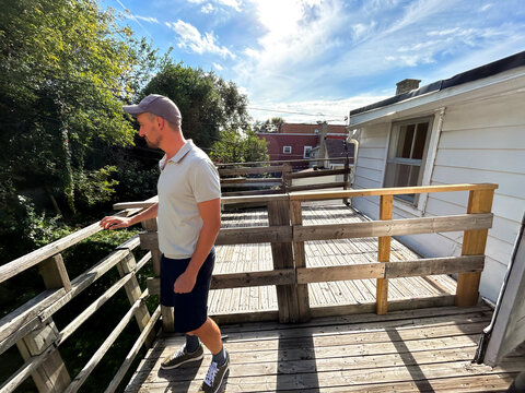 UGC man on the wooden balcony of an apartment