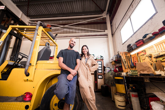 Smiling brother and sister working together at workshop