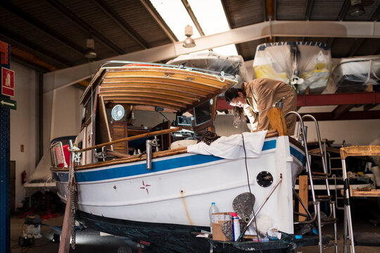 Woman working on boat restoration process