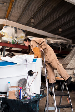 Female mechanic working on boat restoration
