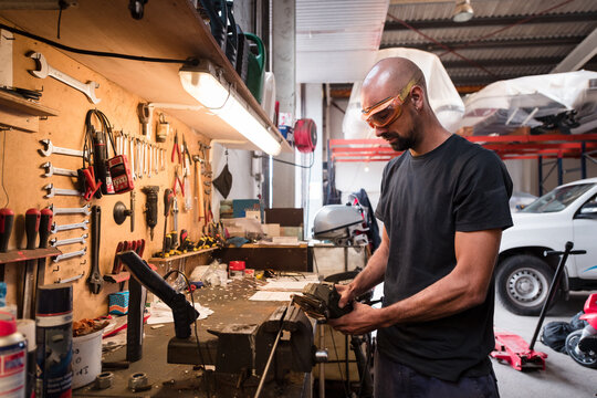 Focused worker using radial saw at boat workshop